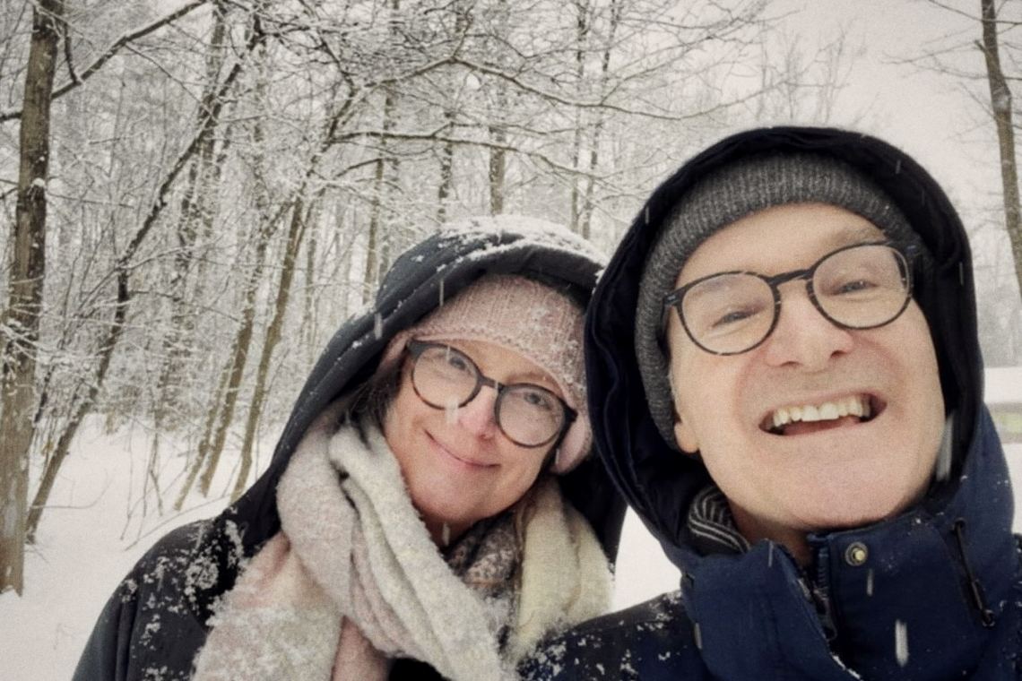 Josée et un homme, tuques et lunettes couvertes de neige, serrés l'un contre l'autre.